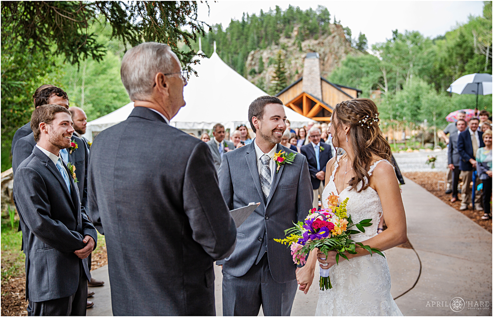 Happy bride and groom under the trees at their outdoor wedding ceremony in Colorado