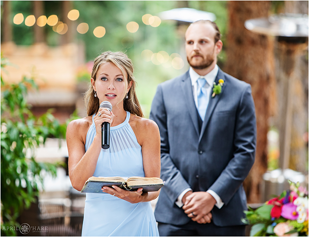 Bridesmaid reads from the bible at an outdoor wedding ceremony at Blackstone Rivers Ranch