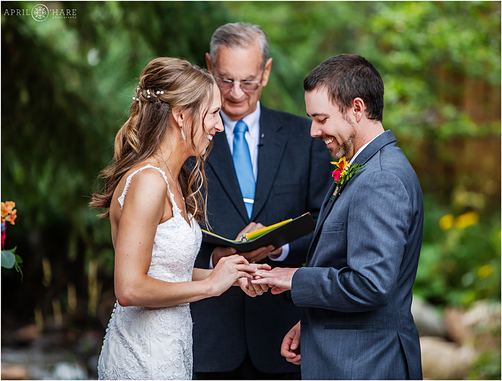 Ring exchange during outdoor wedding ceremony at Blackstone Rivers Ranch in Idaho Springs CO