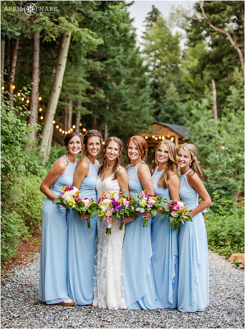 Bride with her bridesmaids in light blue dresses at Colorado mountain wedding