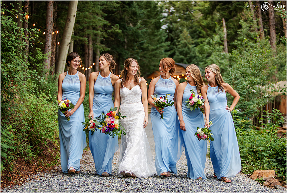 Bride strolls along path with her bridesmaids at Blackstone Rivers Ranch