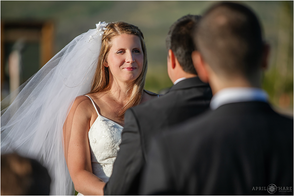 Bride looks at her groom during ceremony at Snow Mountain Ranch