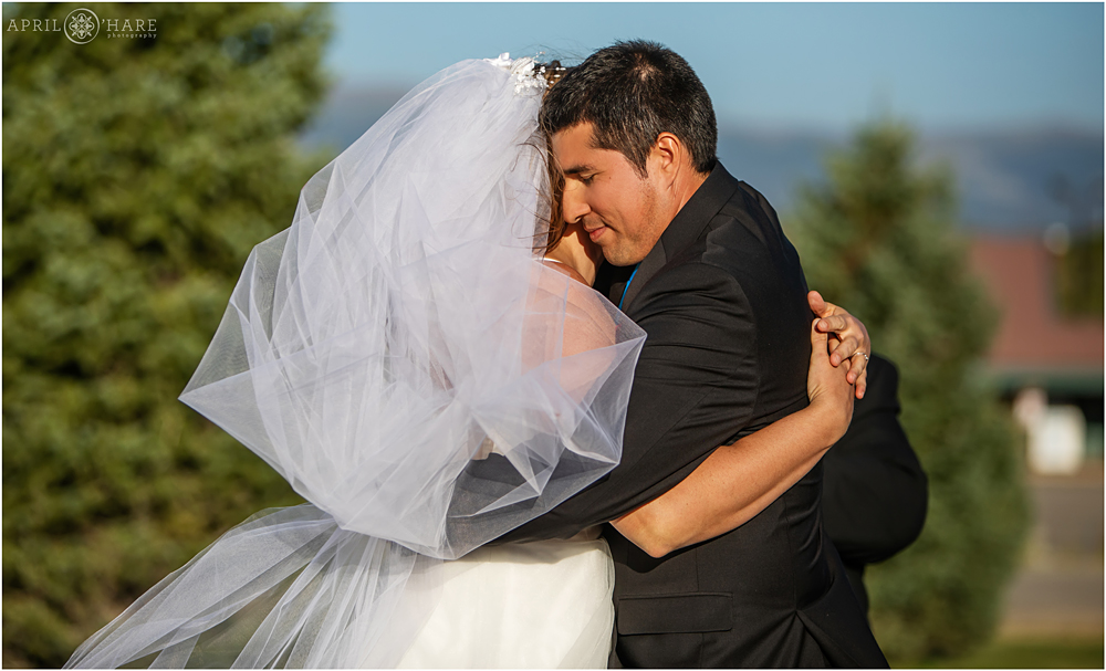 Sweet moment of hugging during wedding ceremony at YMCA of the Rockies in Granby