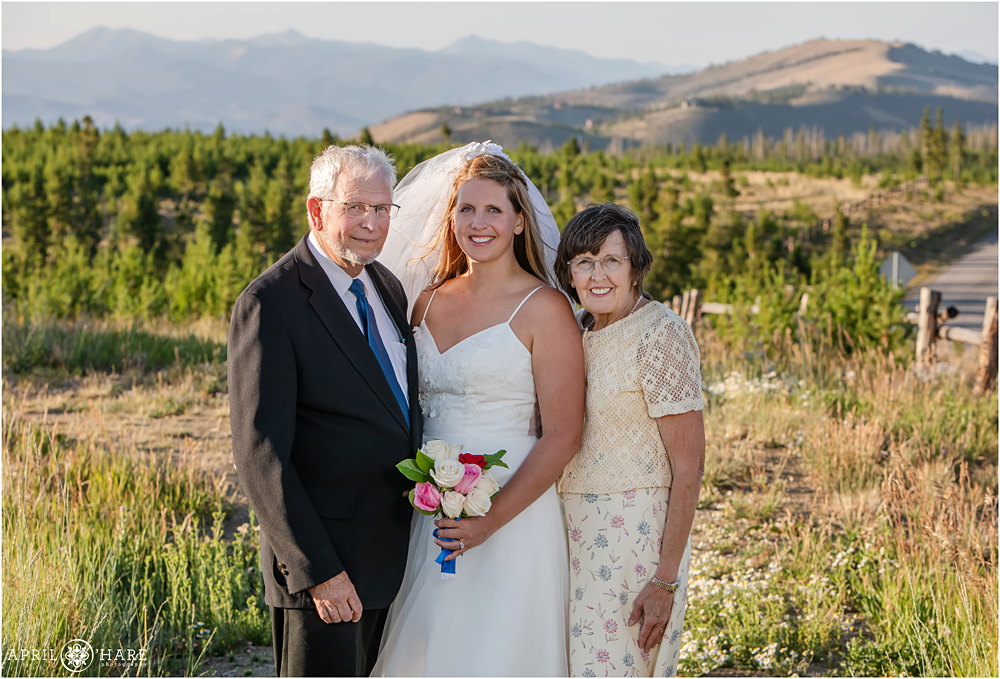 Bride poses for portrait with her parents at Snow Mountain Ranch