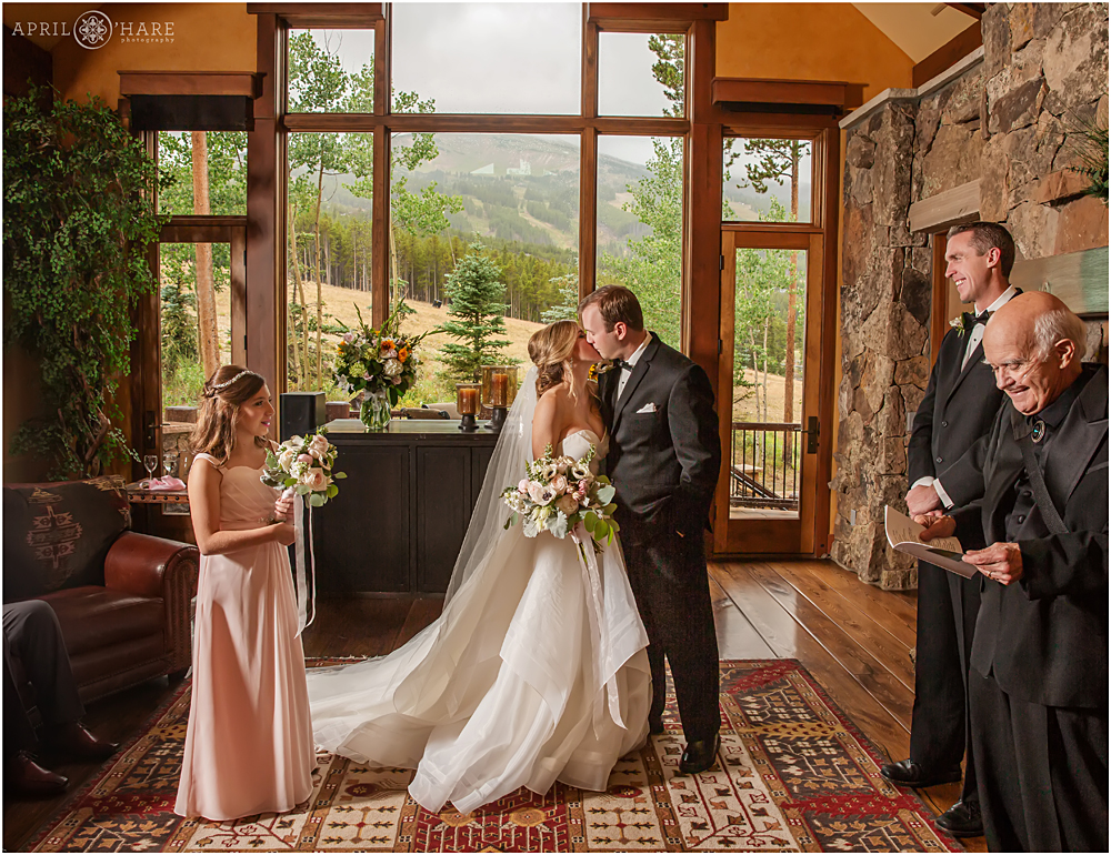 Wedding kiss in front of large windows at a private home in Breckenridge CO
