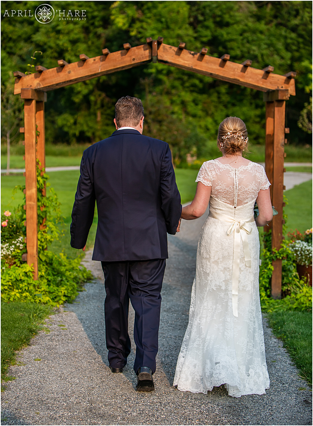 Bride and groom walk away after their Littleton Garden wedding ceremony