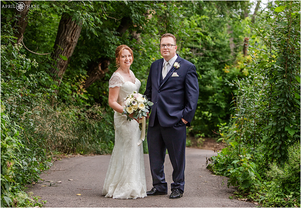 Beautiful portrait of bride and groom on the path in the woods at their Littleton Garden Wedding