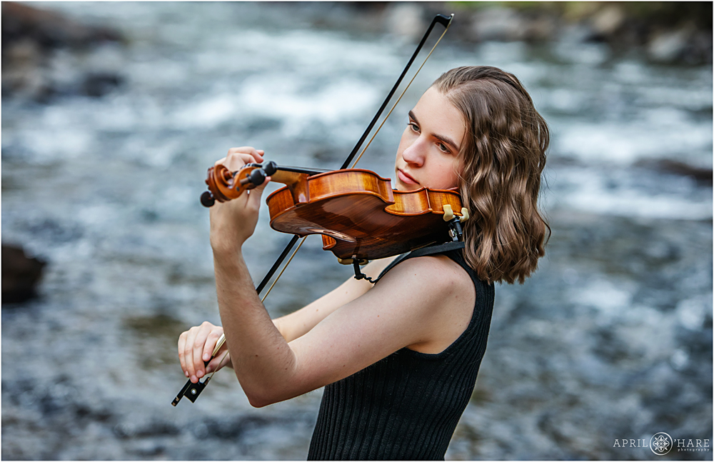 High school senior plays violin at her senior session at Clear Creek Canyon