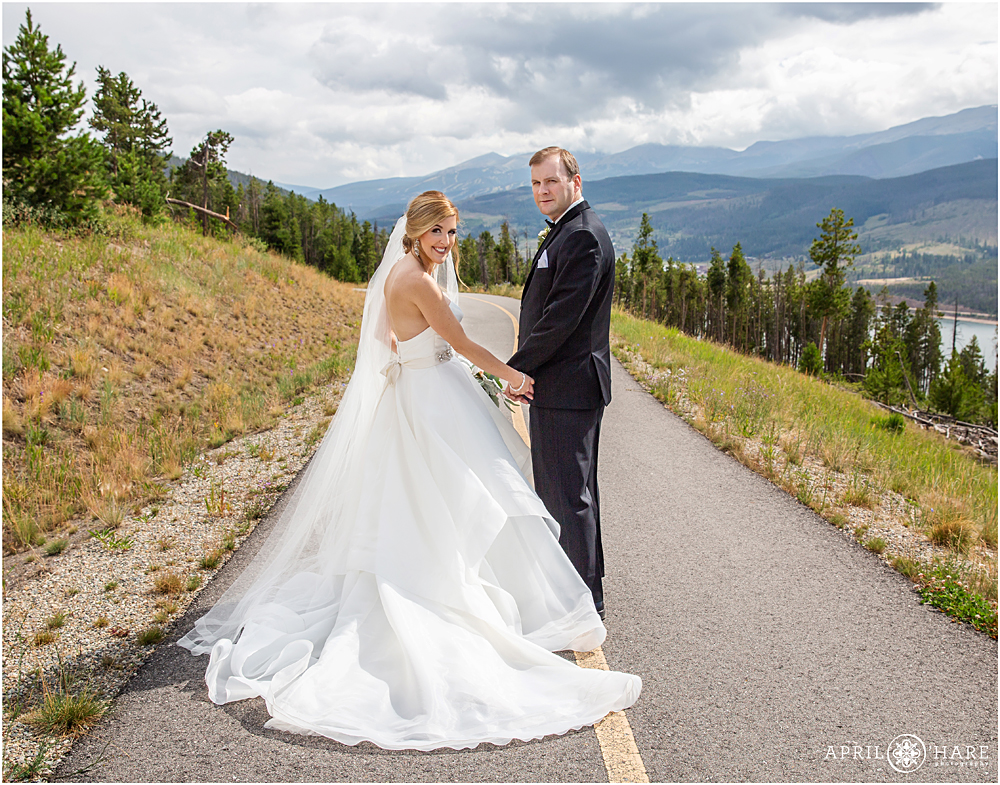 Bride and groom walk down a path at Sapphire Point in Colorado