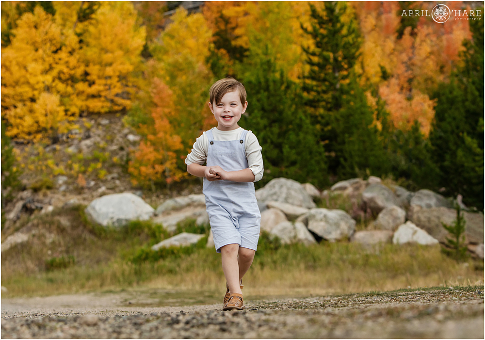 Sweet little boy laughs during family photos during fall color season in Grand Lake 