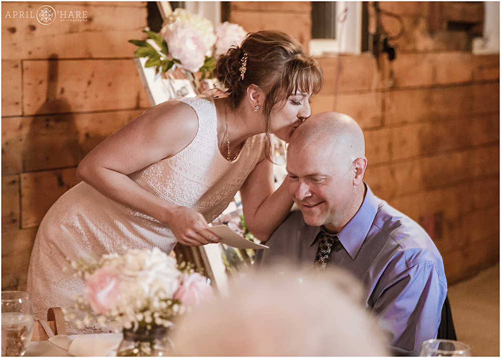Bridesmaid gives a toast and kisses husband at Denver Botanic Gardens Chatfield Farms