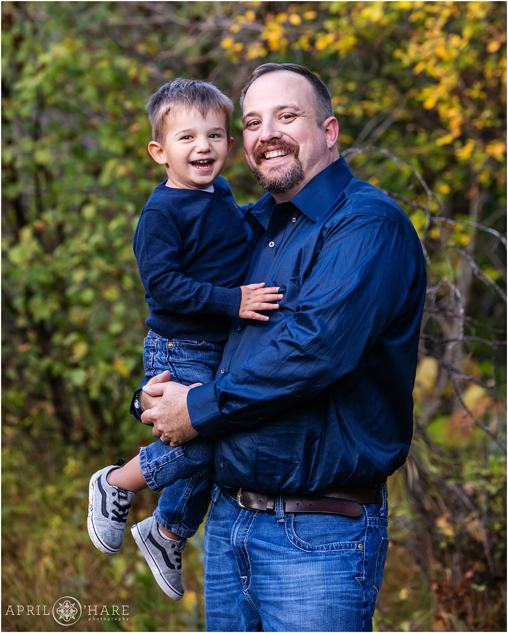 Dad holds his happy young 2 year old son at their family photo session in Colorado