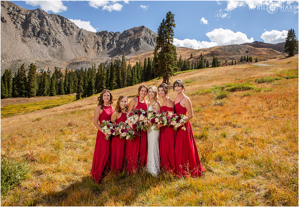 Bride and bridesmaids wearing red at her fall wedding in Colorado