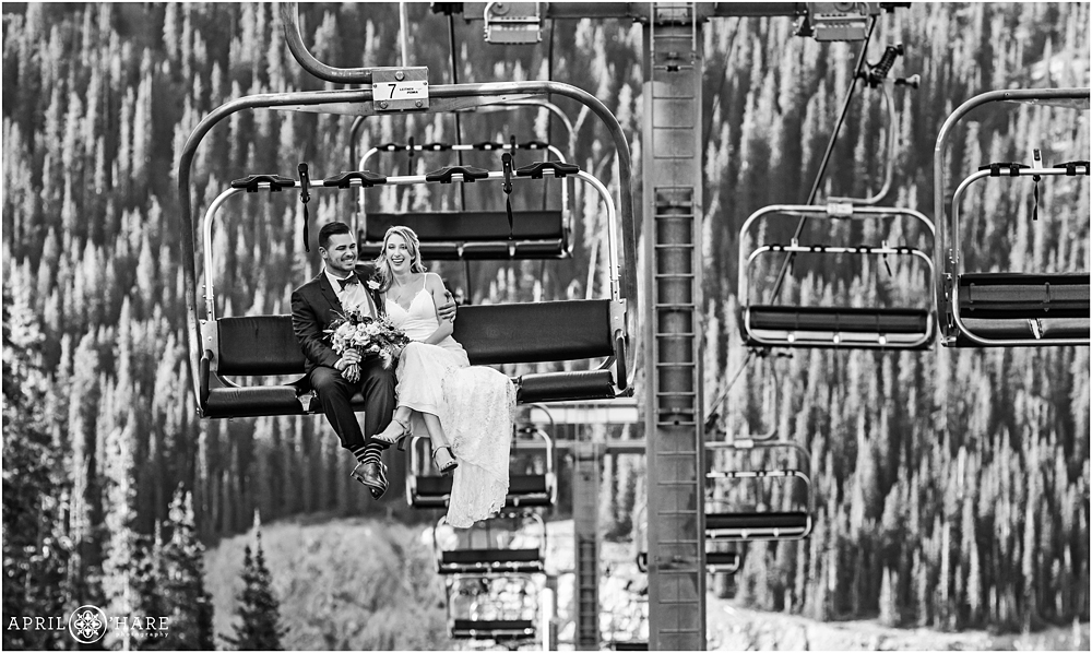 B&W photo of a bride and groom enjoying their chairlift ride at A-Basin in Colorado