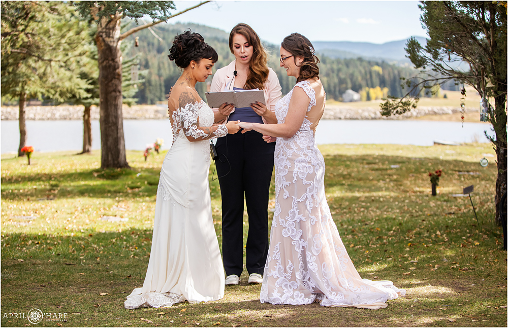Two brides exchange rings at the Barn at Evergreen Memorial Park in CO