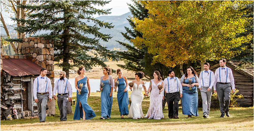 Wedding party walks together on the lawn at The Barn at Evergreen Memorial Park in Colorado