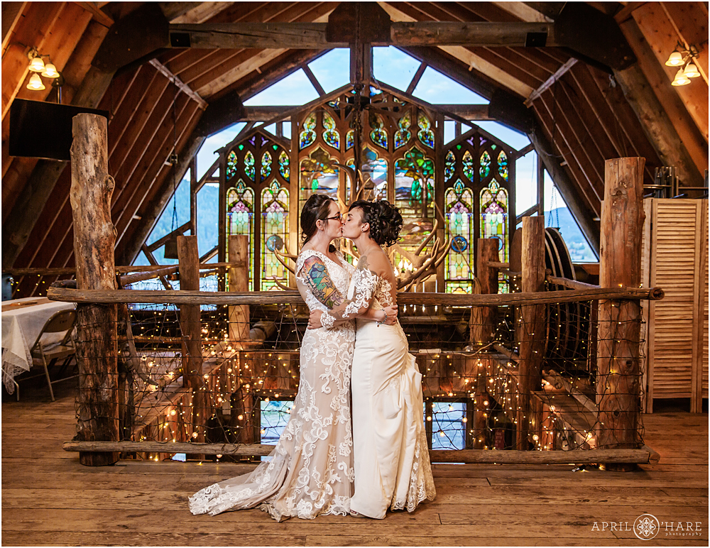 Brides kiss each other at their Colorado same sex wedding at The Barn at Evergreen Memorial Park