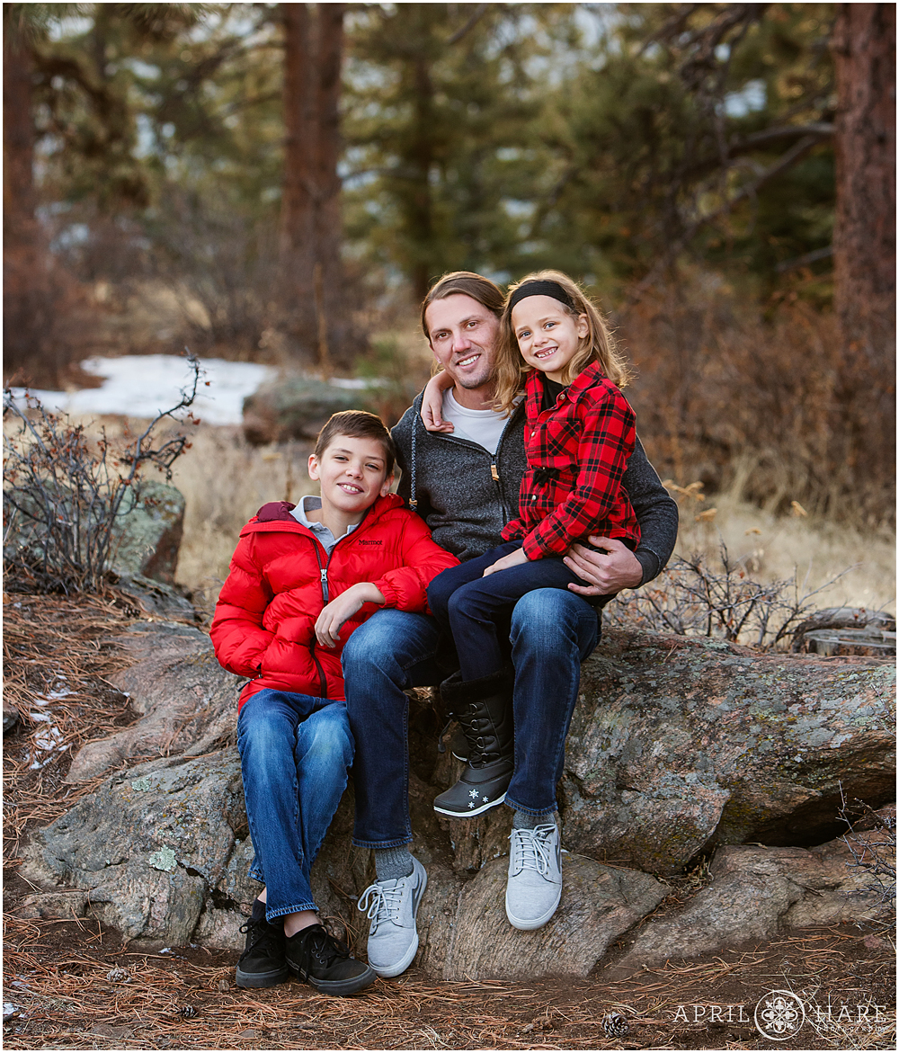 Dad poses for a picture with his kids at their family photos at Mount Falcon in Evergreen CO