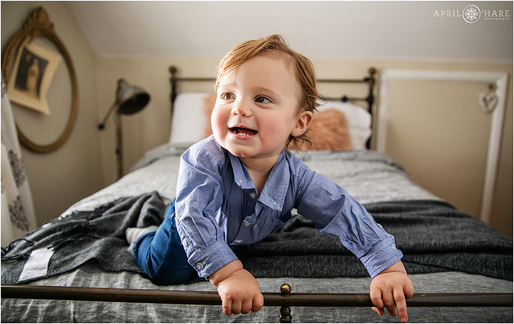 Baby boy smiling on a vintage bed in Littleton CO