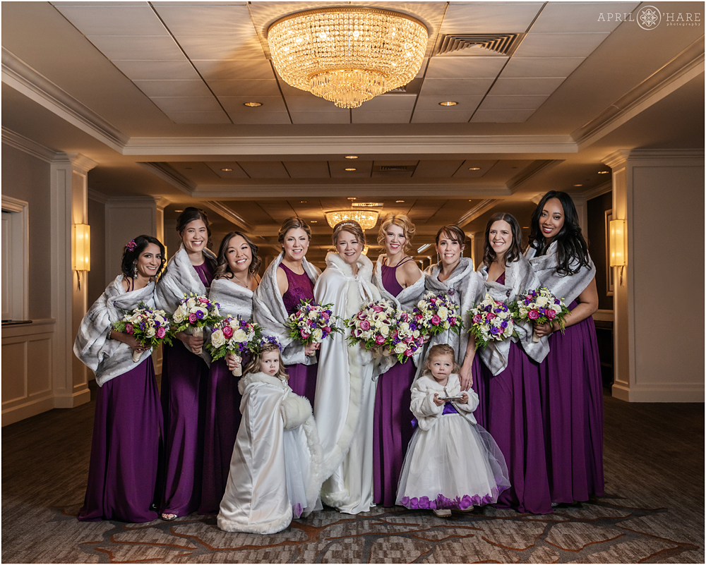 Winter Wedding Inspiration Bridesmaids wearing faux fur shawls and purple dresses