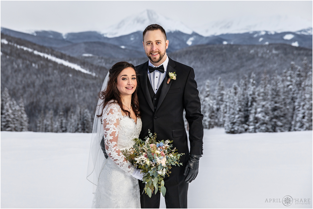 Classic winter wedding portrait with mountain backdrop at Anticipation run Keystone Colorado