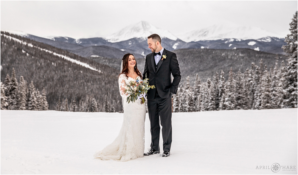 Bride and groom laugh together on their winter wedding day at Keystone Resort in Colorado