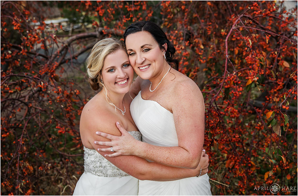 Beautiful lesbian wedding portrait with fall color backdrop