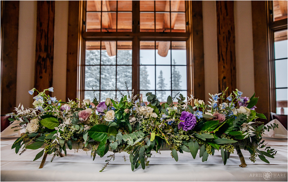 Colorado wedding table floral design with snow covered trees in the windows at Alpenglow Stube Keystone Resort CO