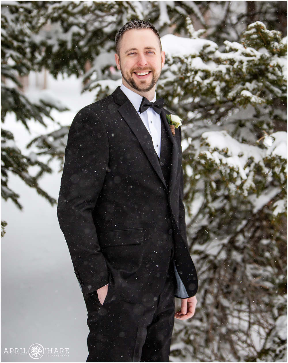 Classic groom portrait with a snow covered tree backdrop at Keystone Resort in Colorado
