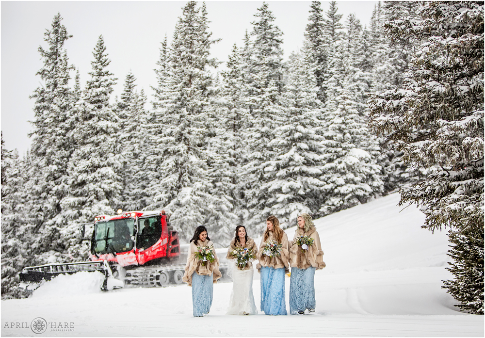 Groomer working in the backdrop of a wedding portrait of a bride with her bridesmaids at Keystone Resort in Colorado