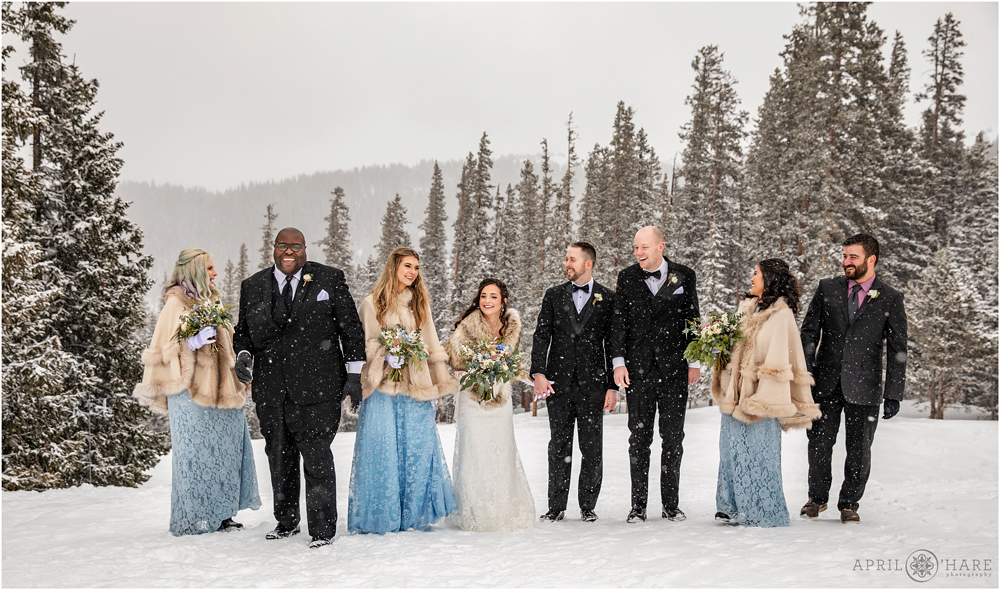 Wedding party walking in a winter wonderland of Keystone Colorado