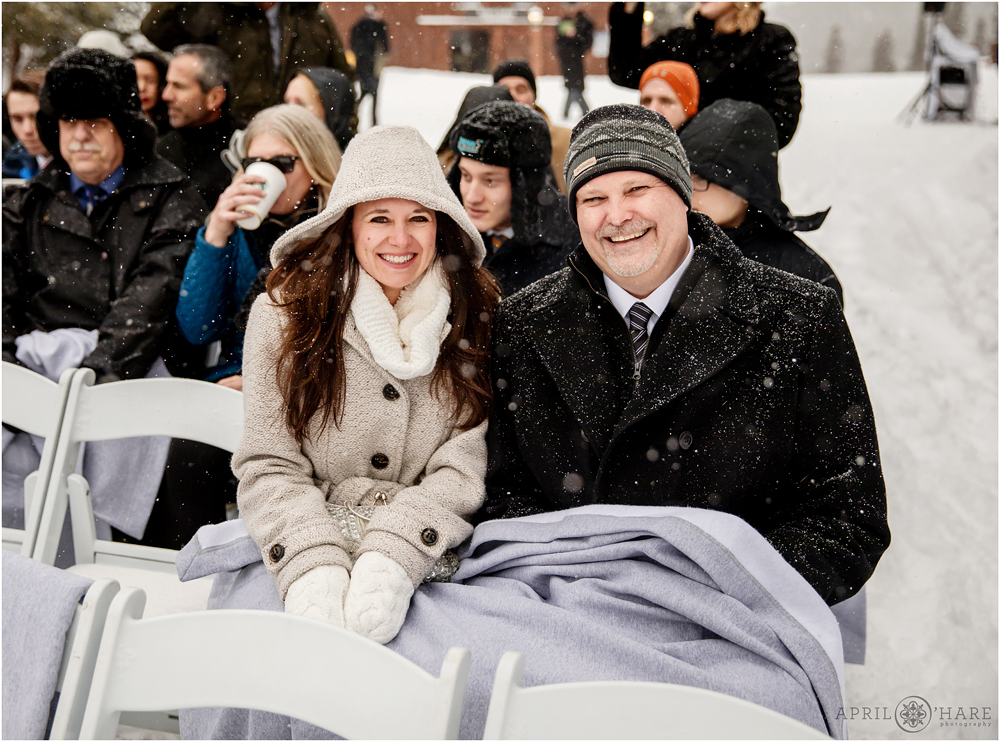 Guests all bundled up and snuggling together for outdoor Colorado destination wedding at Keystone Resort during winter