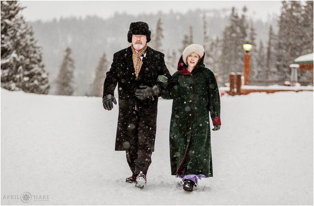 Groom's parents walk to their seats at outdoor winter wedding at Keystone Resort in CO