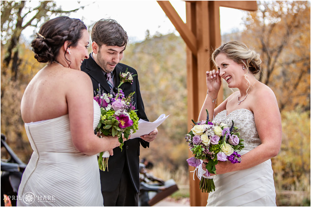 Happy bride looks at her bride at their pretty outdoor fall wedding in Colorado