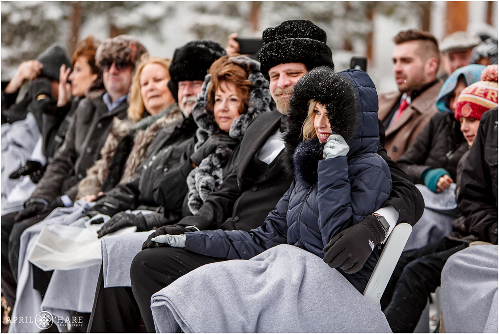 Weddings guests bundled up in coats at outdoor Keystone Colorado wedding ceremony in the mountains