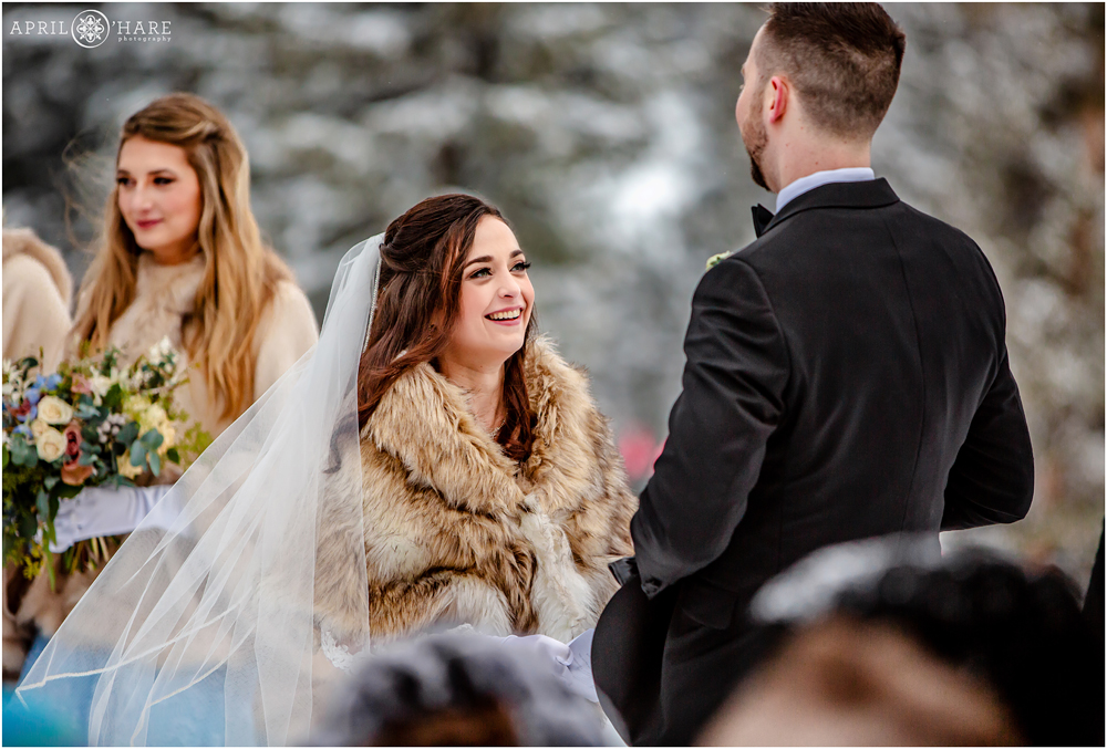 Bride smiles at her groom during their pretty outdoor winter wedding at Keystone Resort