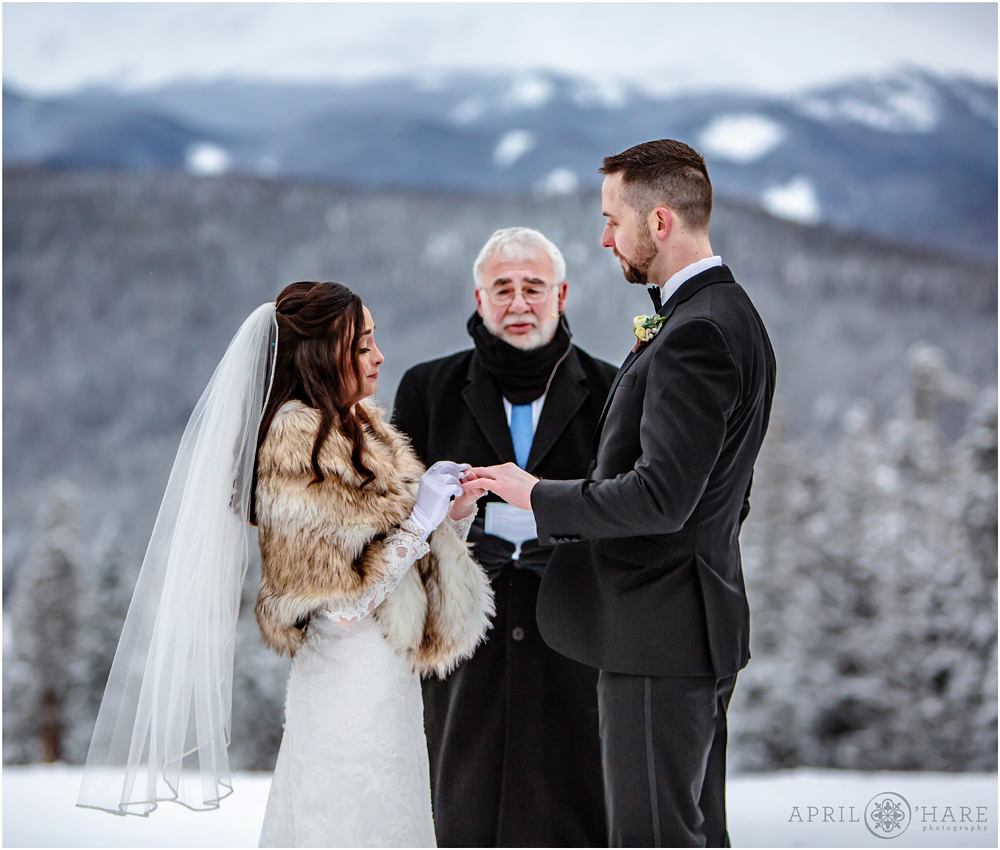 Ring exchange at outdoor winter wedding ceremony at Anticipation run at Keystone Resort