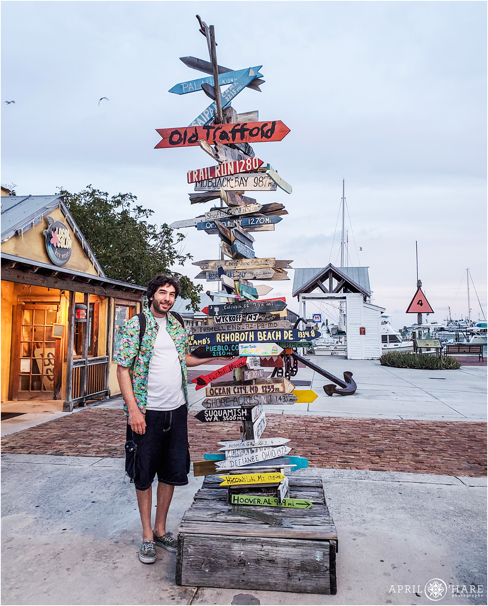 Posing with the mileage sign at the pier in Key West on a road trip through the Florida Keys