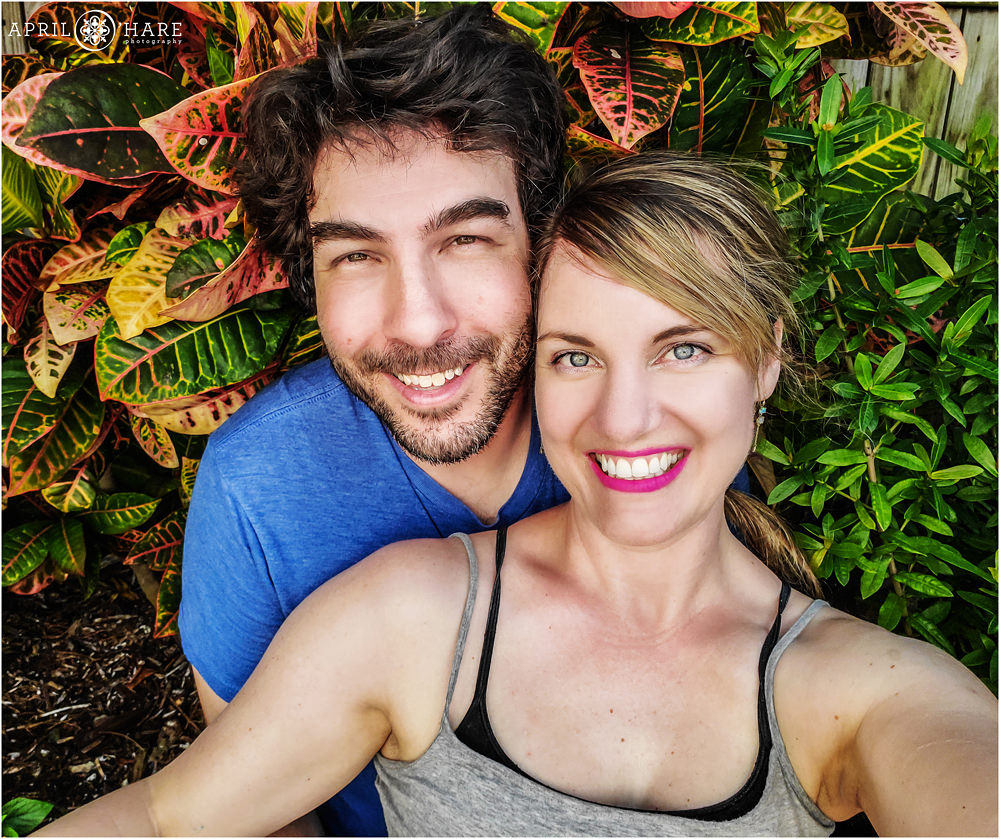 Cute couple poses for a selfie together with a tropical garden backdrop in Key West Florida