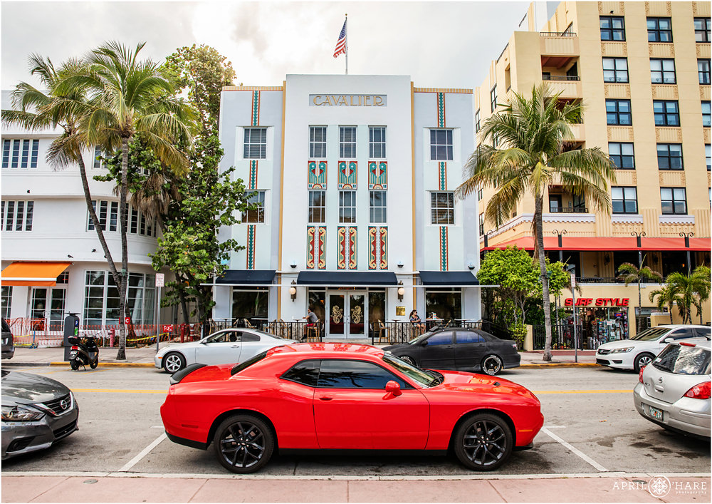 Bright red sports car parked on Ocean Avenue in front of the art deco Cavalier Hotel