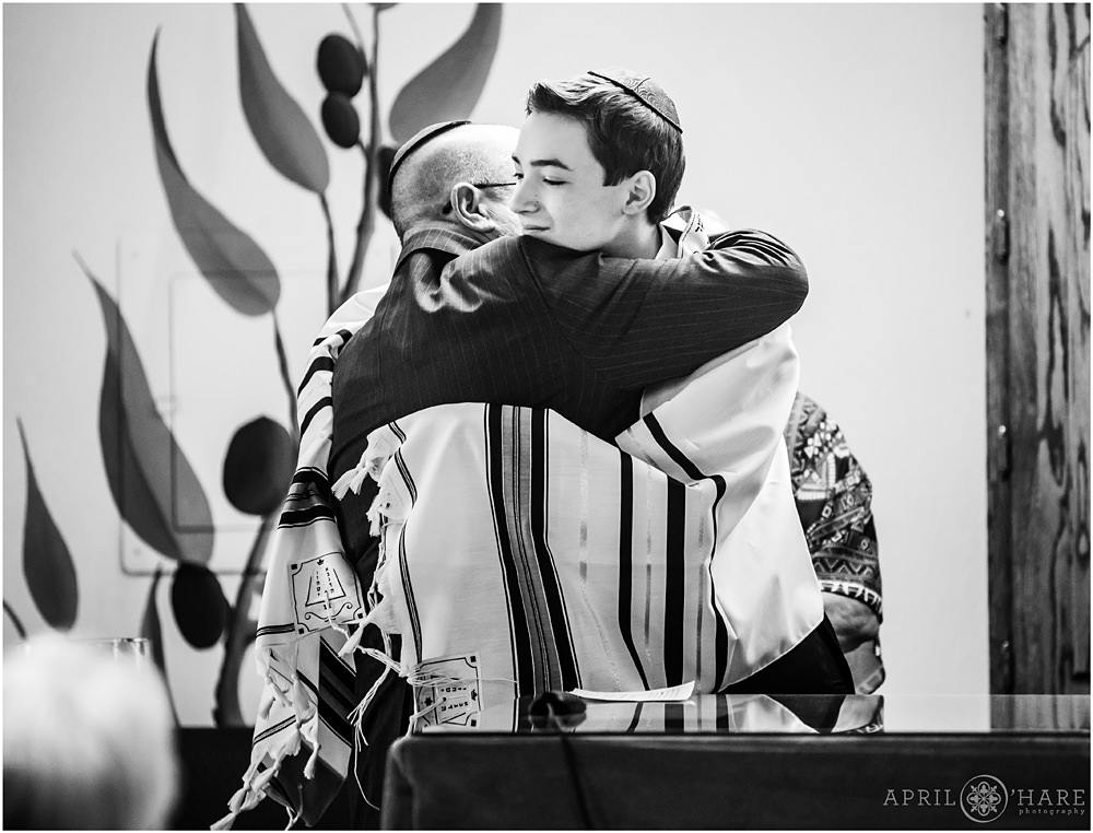 Grandson hugs his grandpa during Bar mitzvah service at B'Nai Chaim