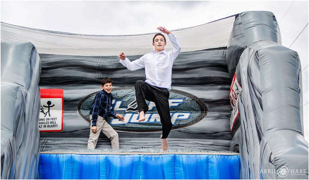 Bar Mitzvah Boy Jumps off of inflatable Cliff Jump at his outdoor Colorado Bar Mitzvah Party