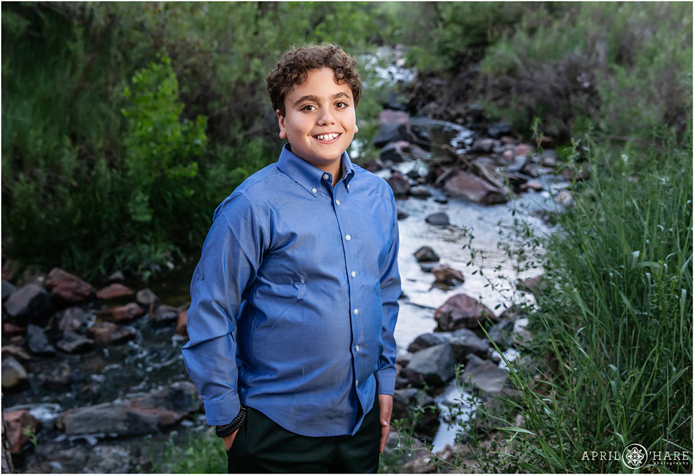 Bar Mitzvah Boy Poses in front of Willow Creek for his portraits in Denver Colorado
