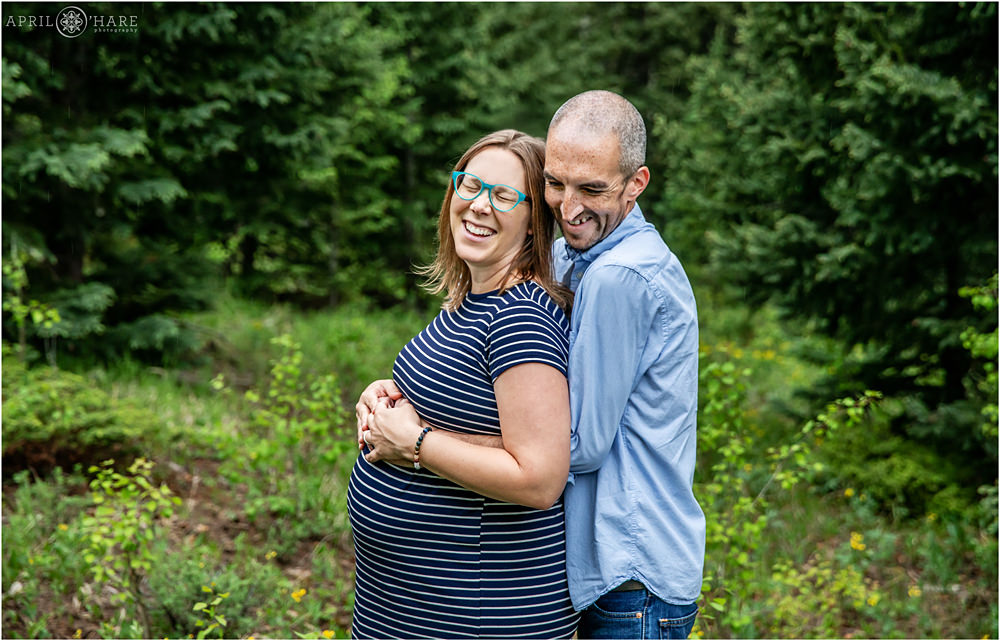 Sweet Happy Moment with Mom and Dad to Be at their Pregnancy Portrait Session in Evergreen