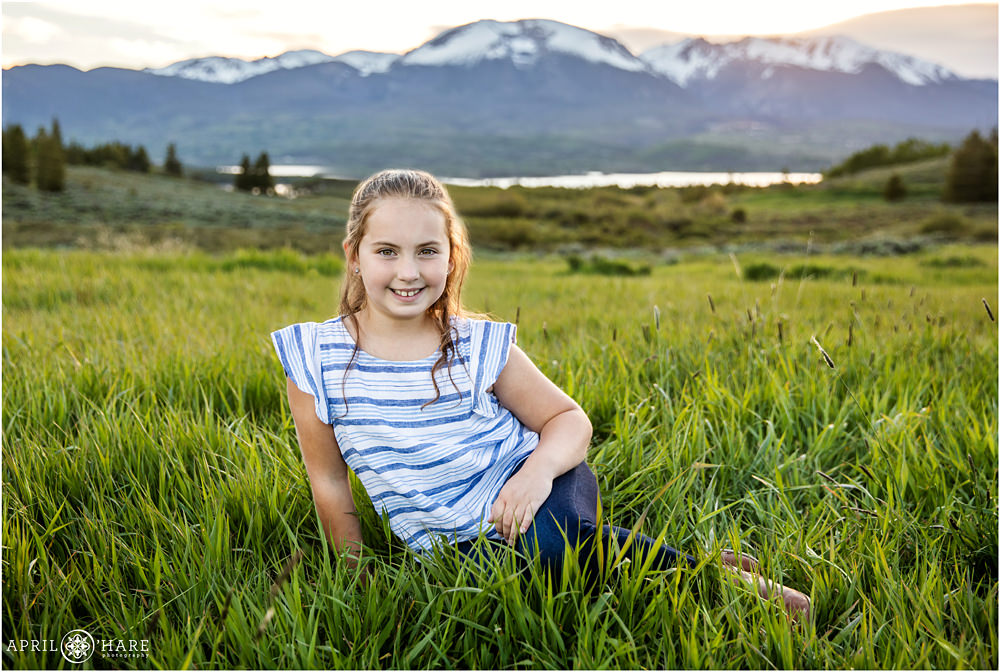Cute girl poses for a portrait in the tall grass in Summit County Colorado