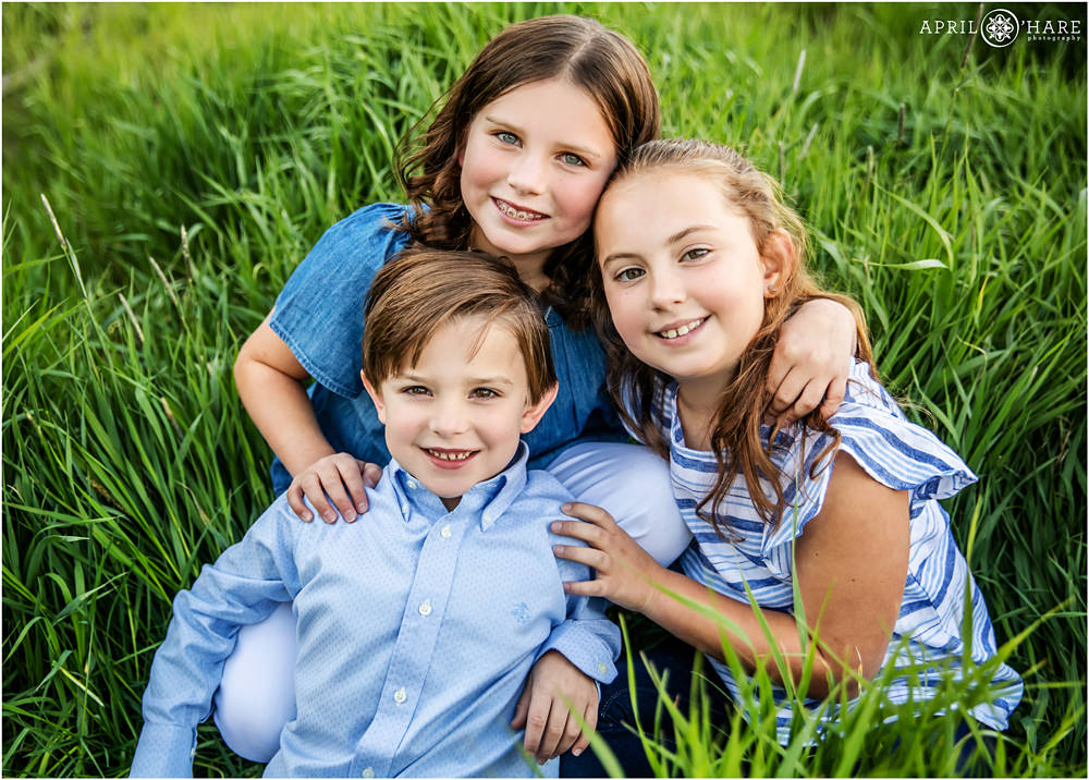 Super cute sibling photo sitting in the green grass at a Summit County Family Photography session in Colorado