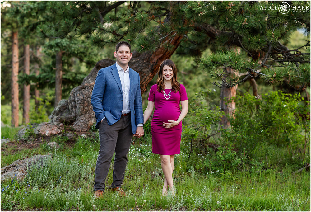 Cute photo of a husband and wife holding hands during their maternity photography session in Colorado
