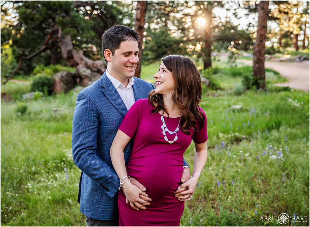 Cute couple smiling at each other during their Colorado Mountain Maternity Photography session in Evergreen