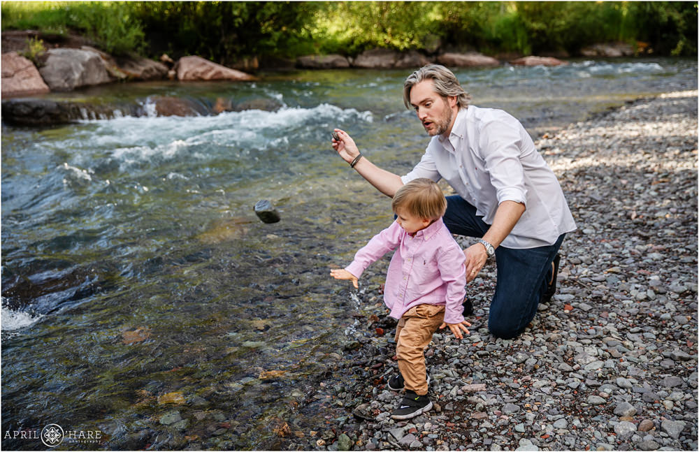Dad and his young son throw rocks into the San Miguel River in Telluride Colorado