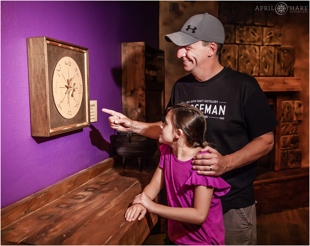A dad and his daughter have fun playing in the Wizard Room at Escape Room Breckenridge for their business promo photos